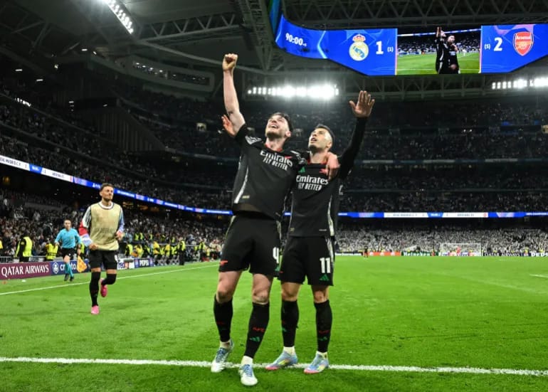 Arsenal players celebrate after scoring against Real Madrid in the 2025 Champions League quarterfinal at Santiago Bernabéu.