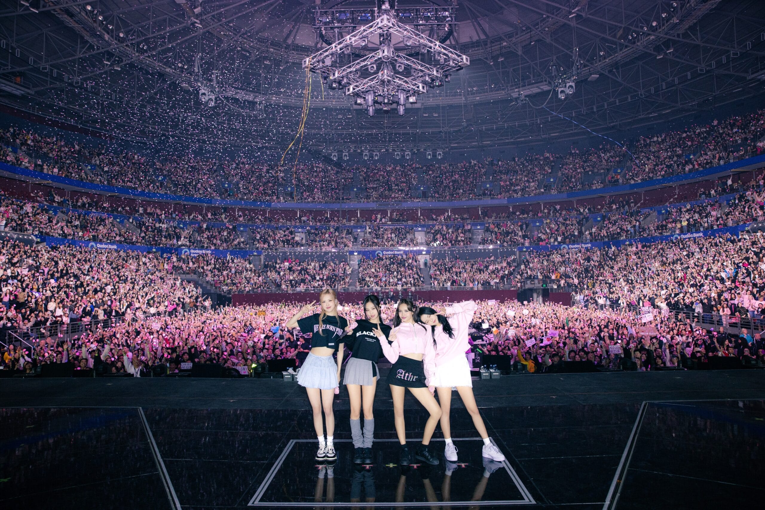 A wide shot of the BLACKPINK concert from the stage, showing the group and the vast audience.